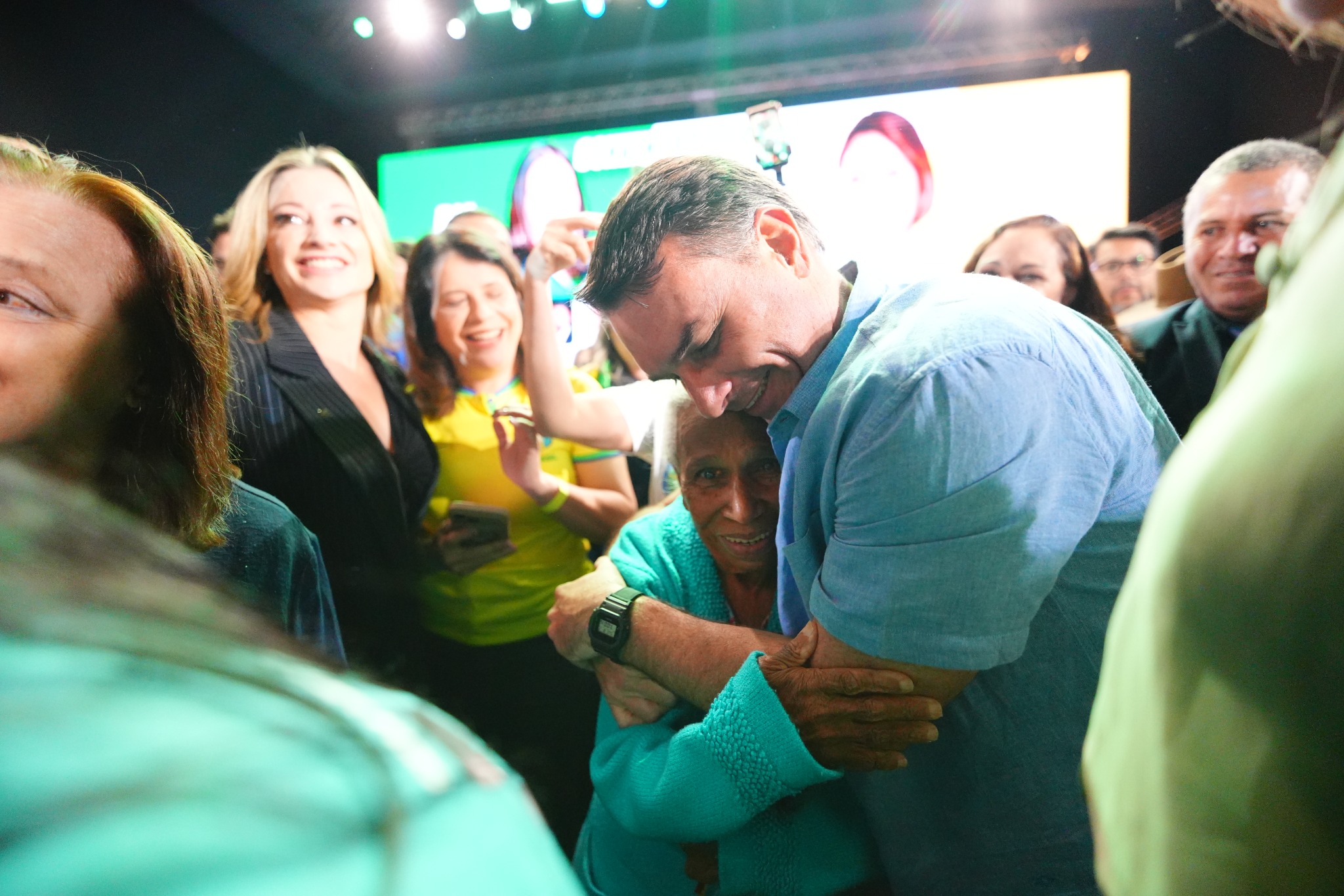 Flávio Bolsonaro abraçando uma apoiadora durante evento público